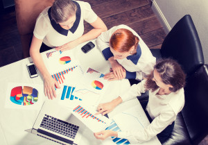 People Looking at Charts While Sitting at Table